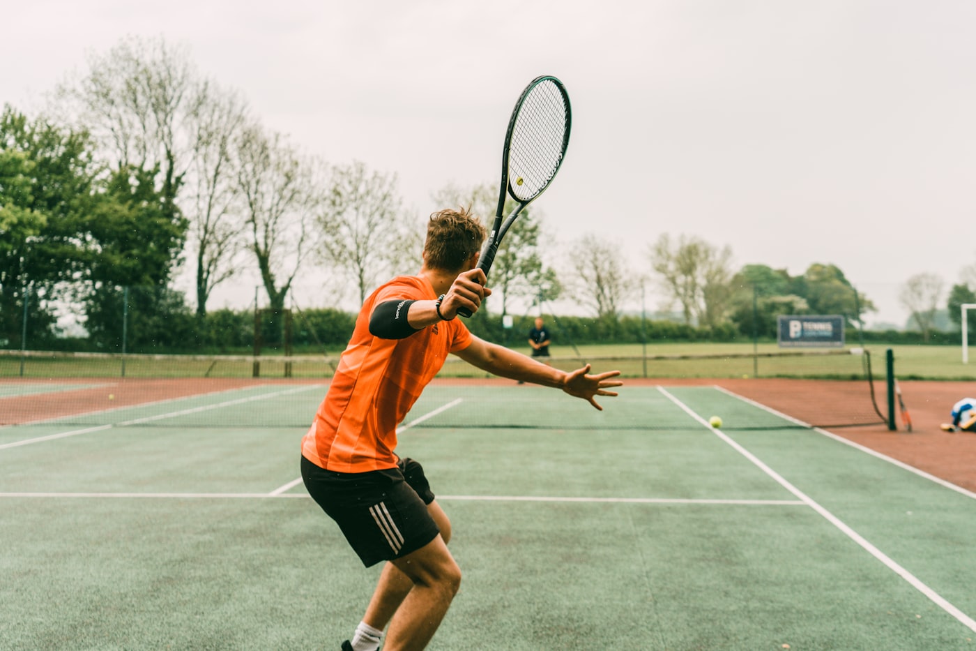 Tennis player on an outdoor court preparing to hit